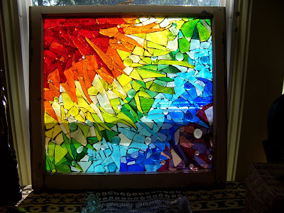 colored broken glass organized and glued in a rainbow shape
