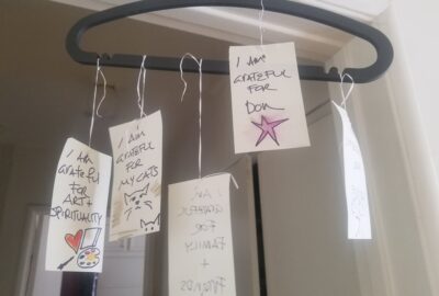 hanger with pieces of paper with notes of gratitude hanging in a doorway